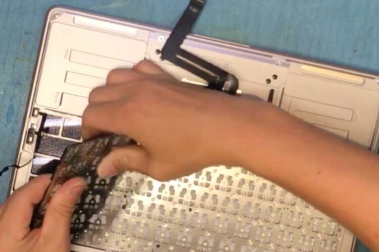 Technician replacing Macbook air keyboard